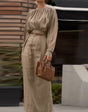Elegant outfit with a round neck, long sleeves, and pleats.