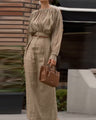 Elegant outfit with a round neck, long sleeves, and pleats.