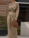 Elegant outfit with a round neck, long sleeves, and pleats.