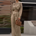 Elegant outfit with a round neck, long sleeves, and pleats.